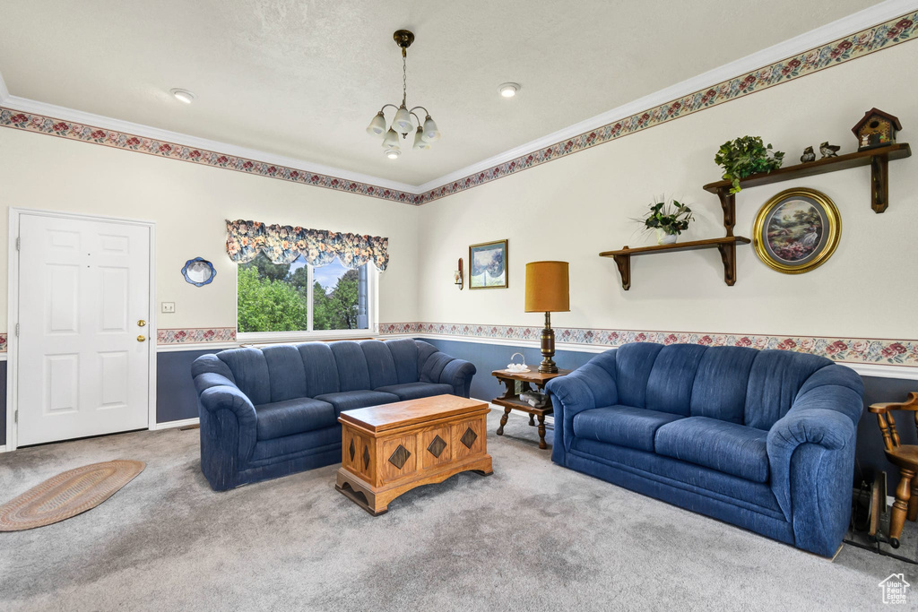 Living area with carpet flooring, crown molding, and a chandelier
