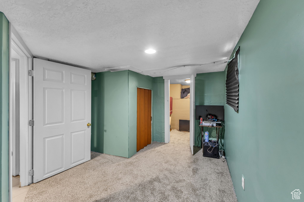 Finished basement with carpet floors and a textured ceiling