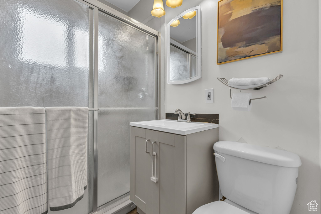 Bathroom with a stall shower, toilet, and vanity