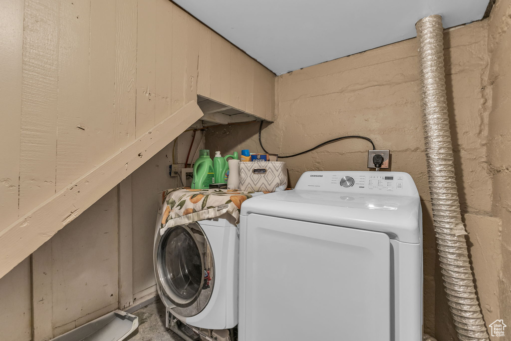 Laundry room with independent washer and dryer and concrete block wall