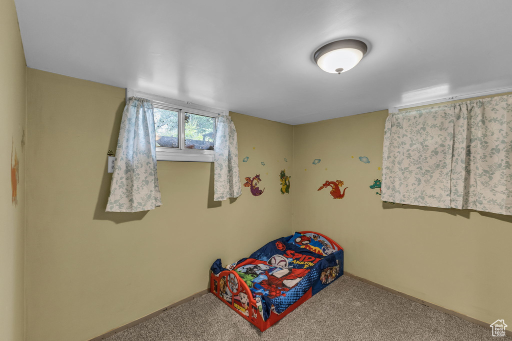 Bedroom featuring carpet and baseboards