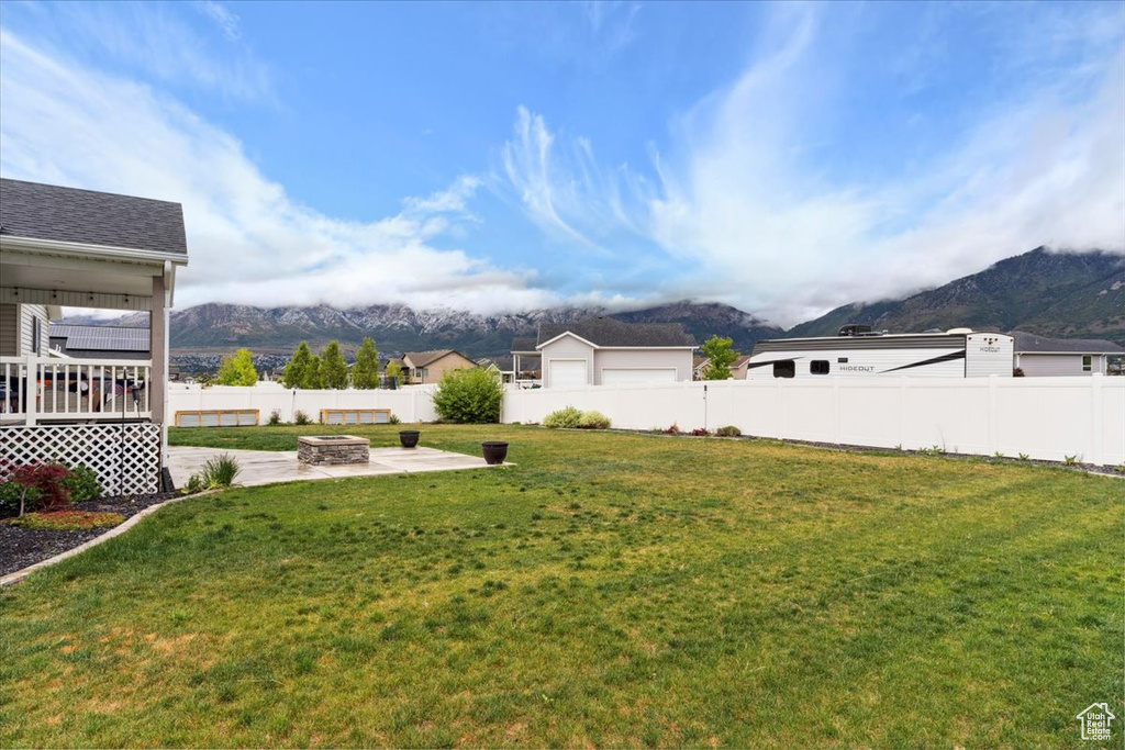 View of yard with a mountain view, a patio area, and a fire pit