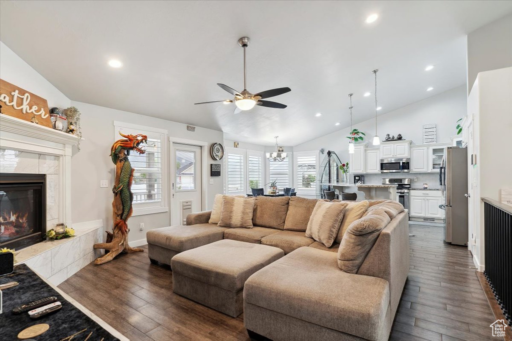 Living area with a fireplace, a ceiling fan, dark wood-style floors, a chandelier, and recessed lighting