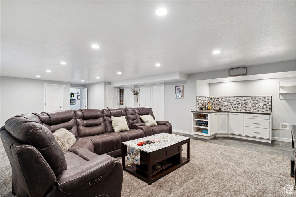 Living area with a bar, recessed lighting, and baseboards