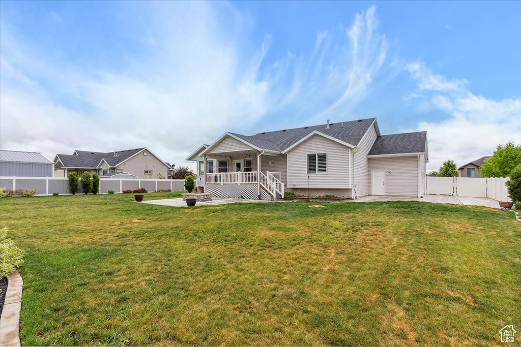Back of house with an outdoor fire pit and a patio