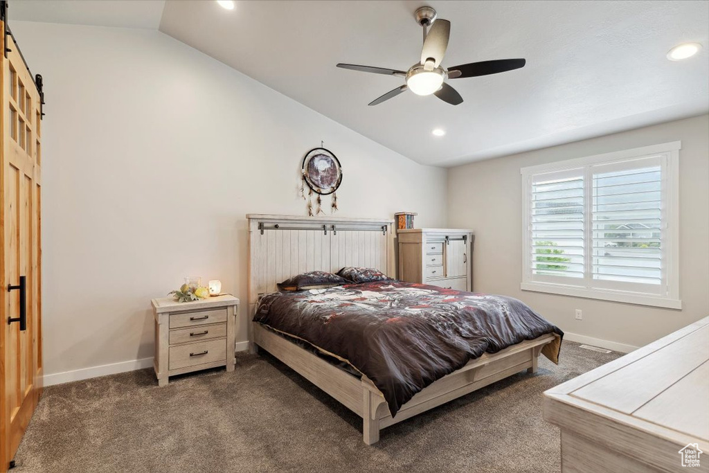 Bedroom featuring a barn door, vaulted ceiling, carpet flooring, baseboards, and recessed lighting