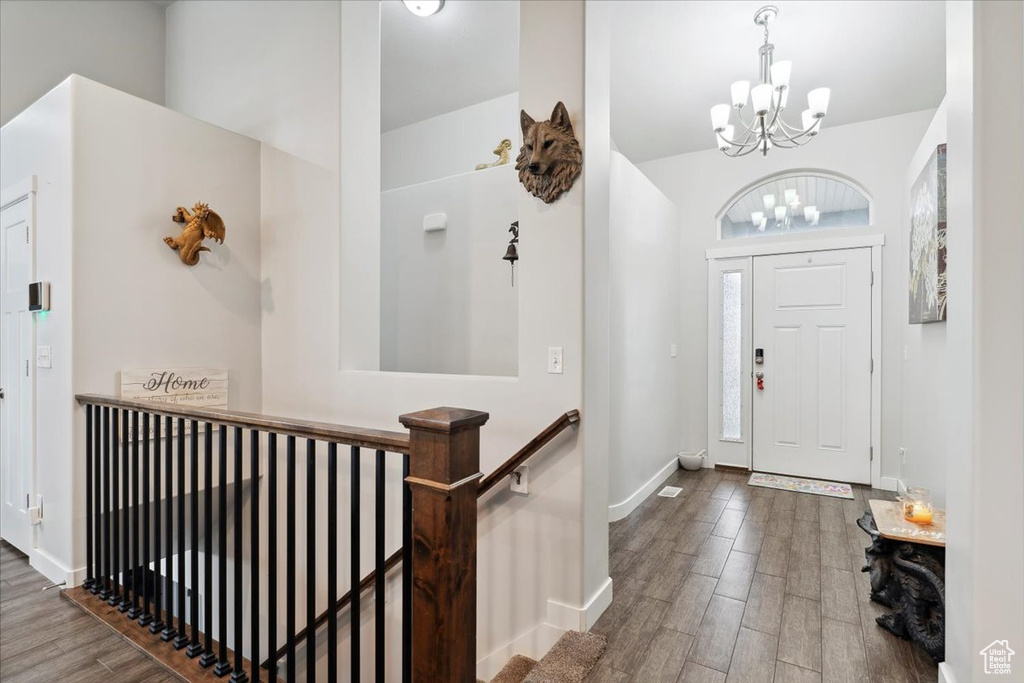 Foyer with a chandelier, wood finished floors, and baseboards