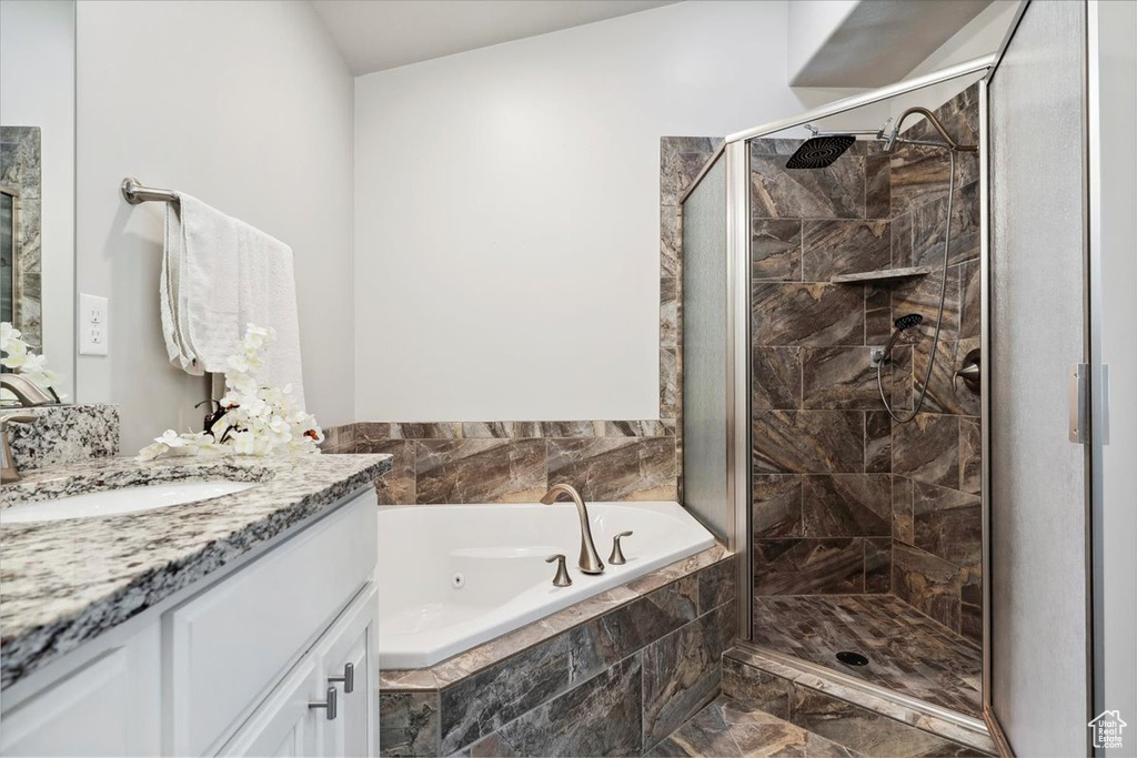 Full bath with a stall shower, a tub with jets, marble look tile flooring, and vanity