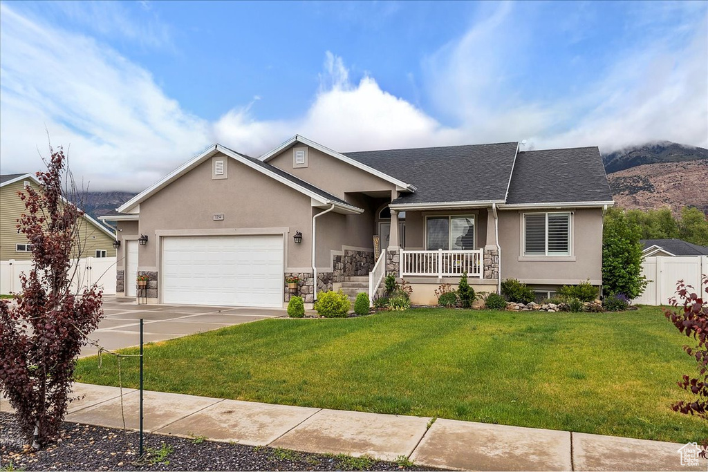 Single story home featuring stucco siding, covered porch, a garage, and driveway