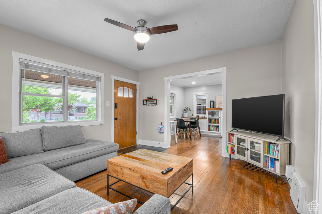 Living area with hardwood / wood-style floors, a ceiling fan, and baseboards