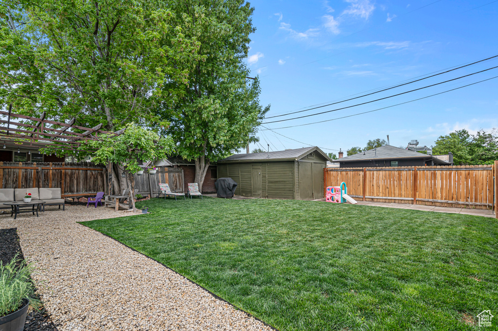 View of yard featuring a storage shed, an outdoor structure, and a patio