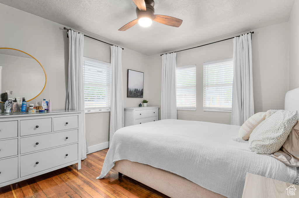 Bedroom featuring hardwood / wood-style floors, baseboards, and ceiling fan