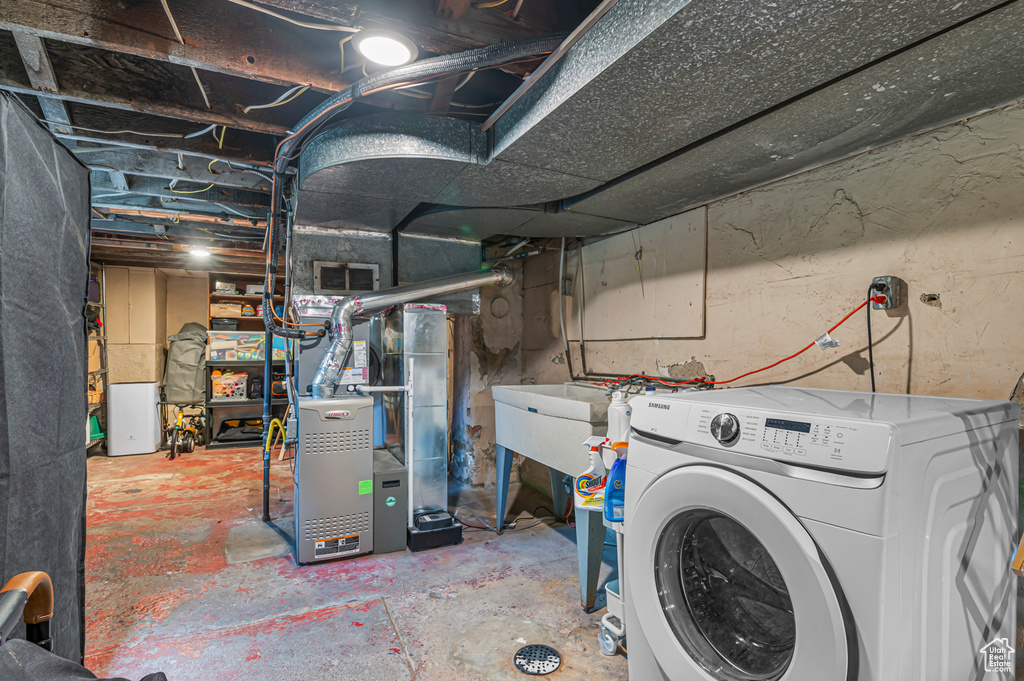 Unfinished basement featuring washer / dryer and heating unit