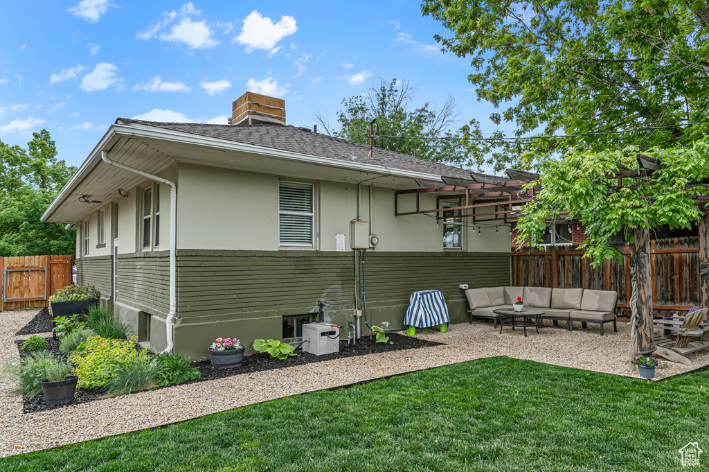 Back of property with outdoor lounge area, a patio, roof with shingles, and stucco siding