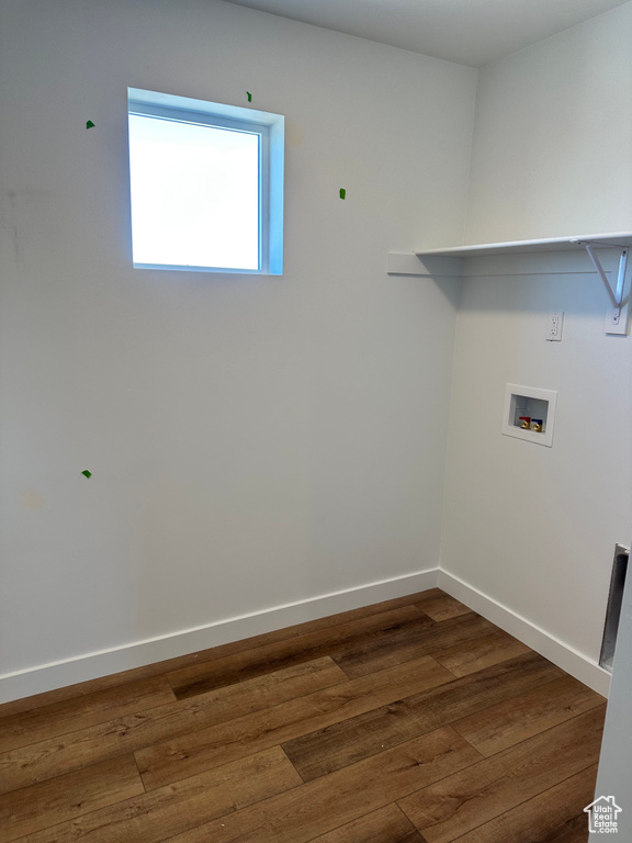 Clothes washing area featuring hookup for a washing machine, wood-type flooring, and baseboards