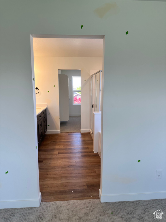 Hallway with baseboards and wood finished floors
