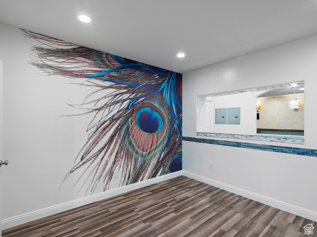 Detailed view of wood finished floors, recessed lighting, baseboards, and electric panel