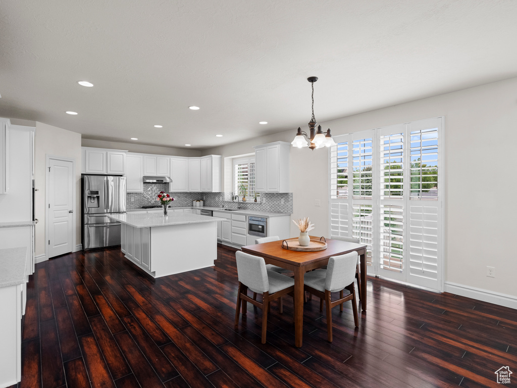 Dining space with a chandelier, dark wood-style floors, recessed lighting, and baseboards