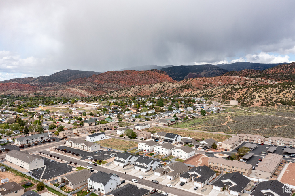 Aerial view of property and surrounding area featuring a mountainous background and nearby suburban area