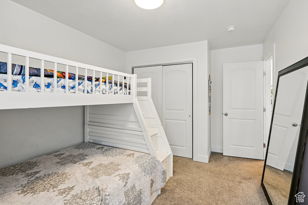 Unfurnished bedroom featuring carpet flooring and a closet