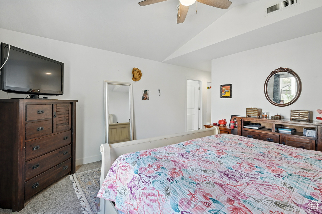 Bedroom with light carpet, vaulted ceiling, and ceiling fan
