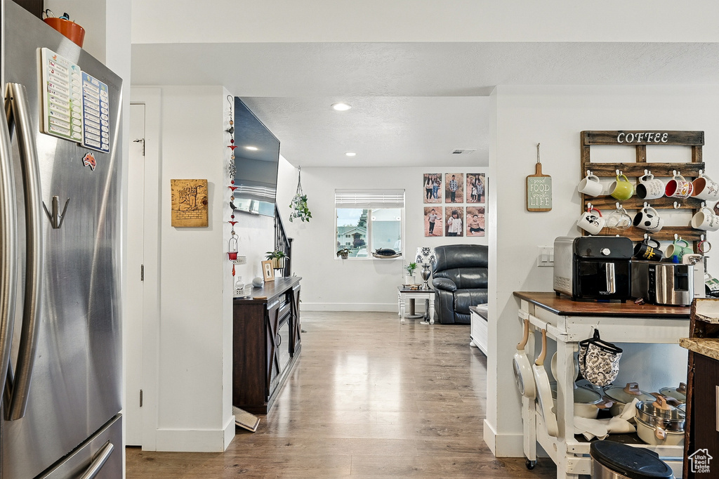 Kitchen featuring freestanding refrigerator, wood finished floors, baseboards, and recessed lighting