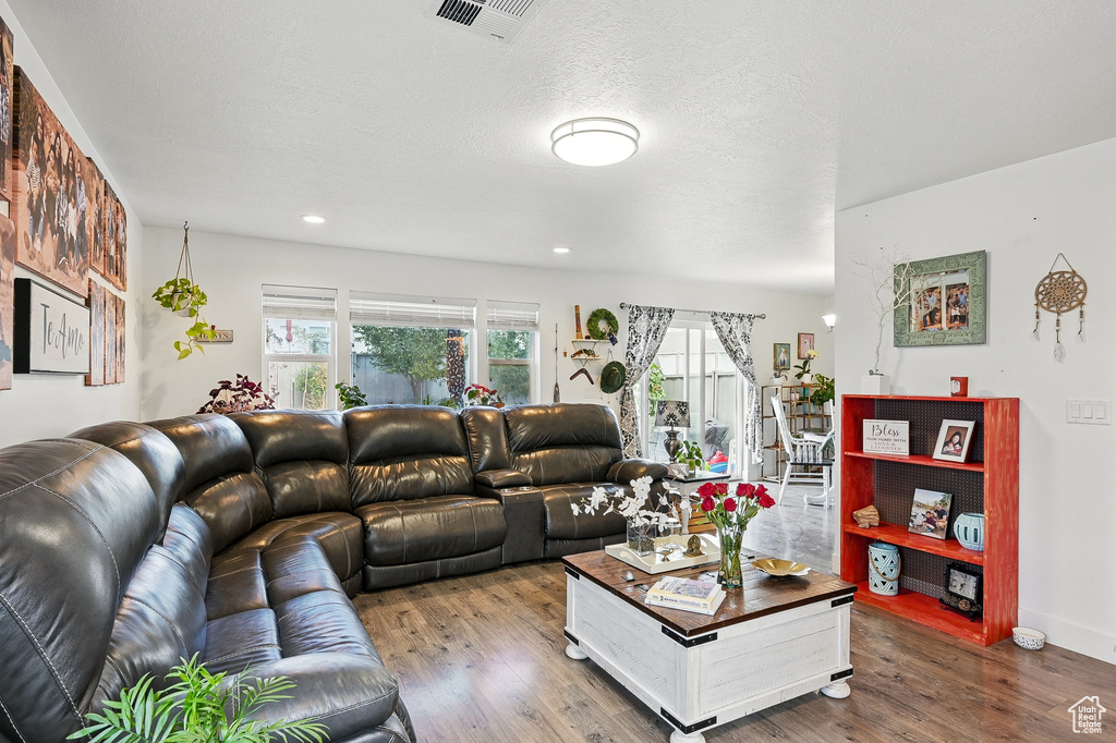 Living area with wood finished floors and recessed lighting