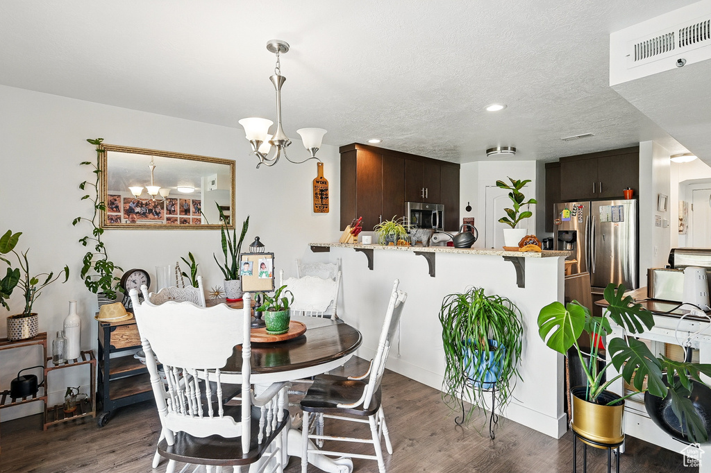 Dining space with a chandelier, wood finished floors, and recessed lighting