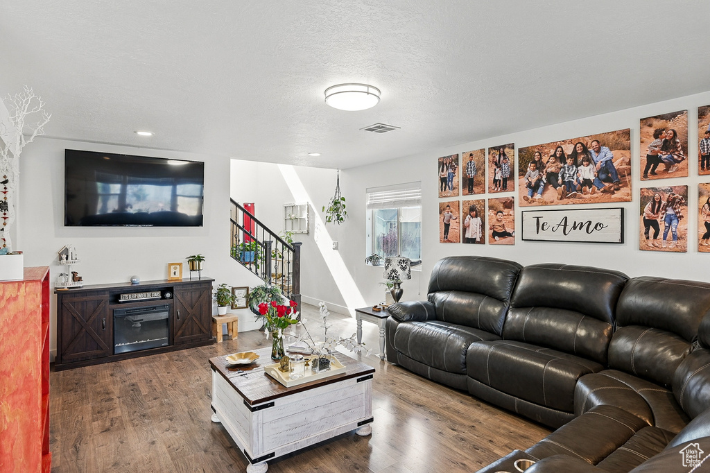 Living area featuring stairs, dark wood finished floors, and recessed lighting