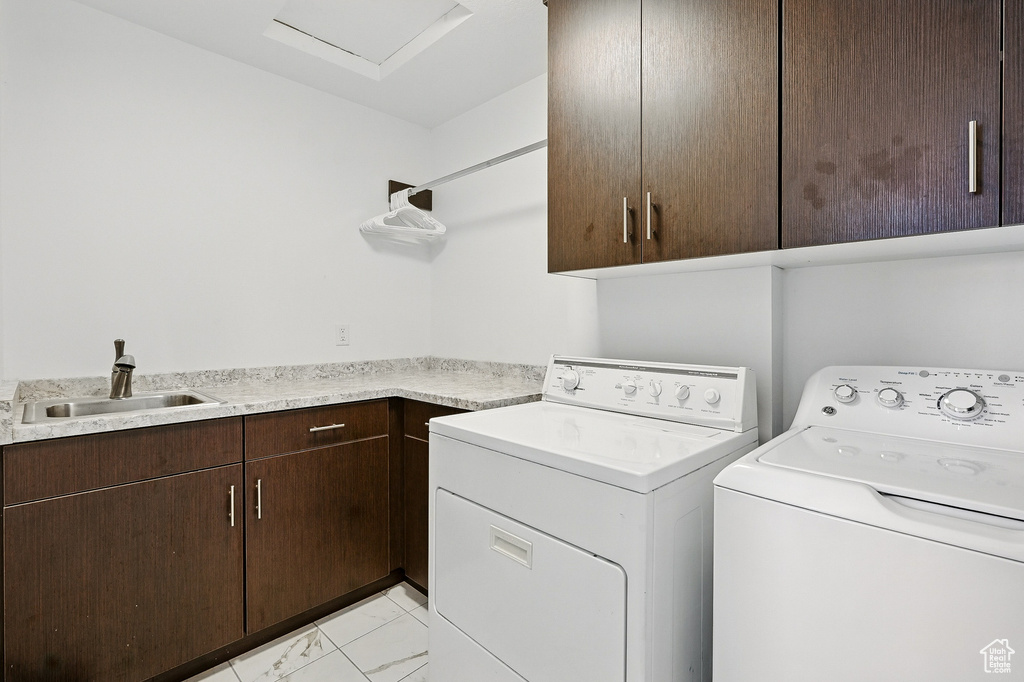 Laundry room featuring cabinet space, washing machine and clothes dryer, and light marble finish floors