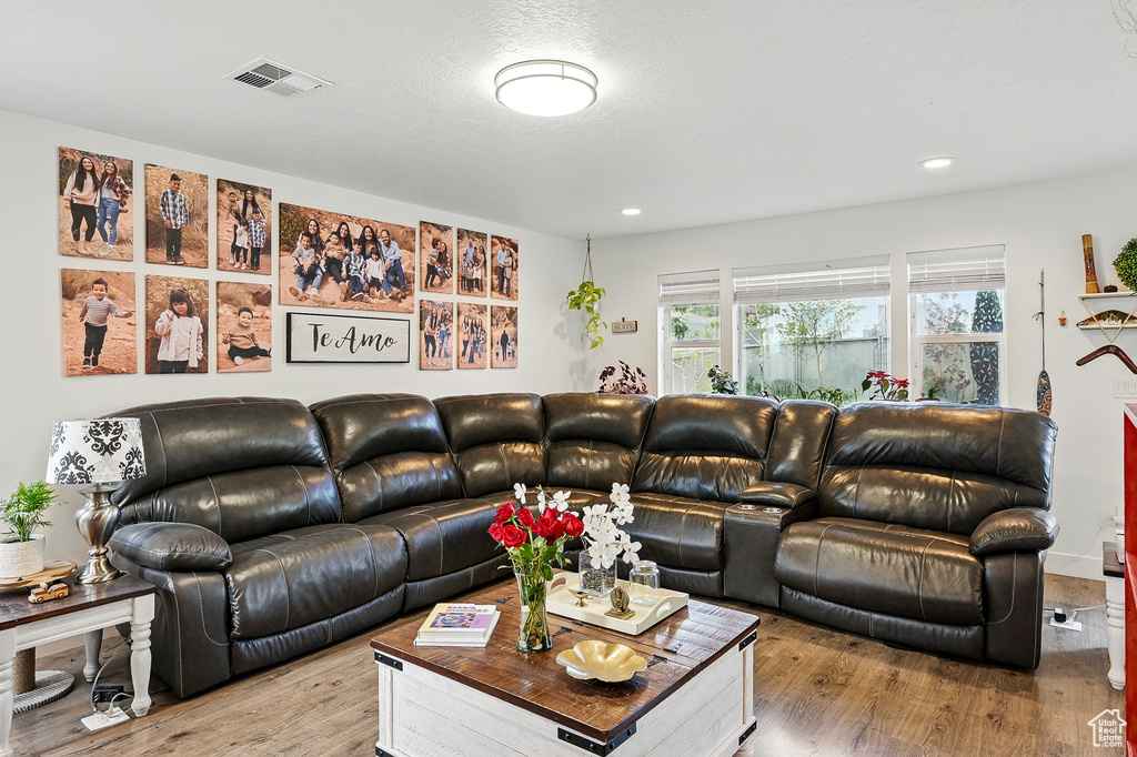 Living room with light wood-style flooring and recessed lighting