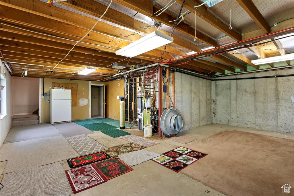 Unfinished basement with freestanding refrigerator