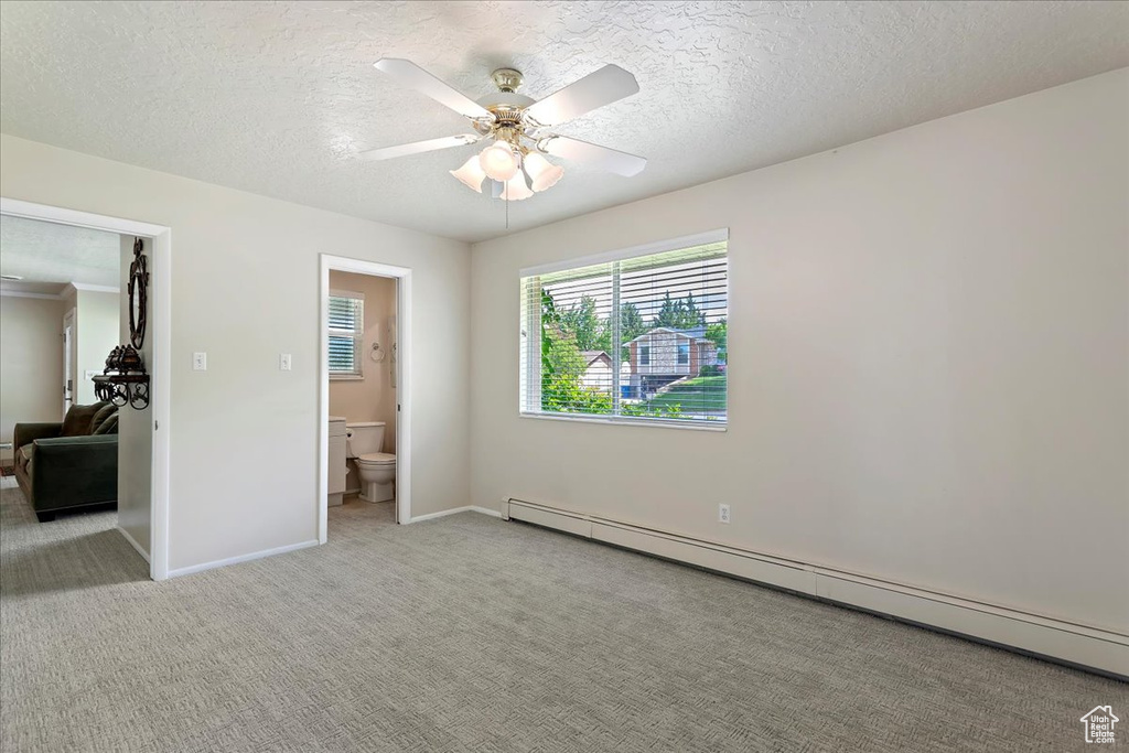 Unfurnished bedroom featuring a baseboard radiator, a textured ceiling, carpet floors, baseboards, and a ceiling fan