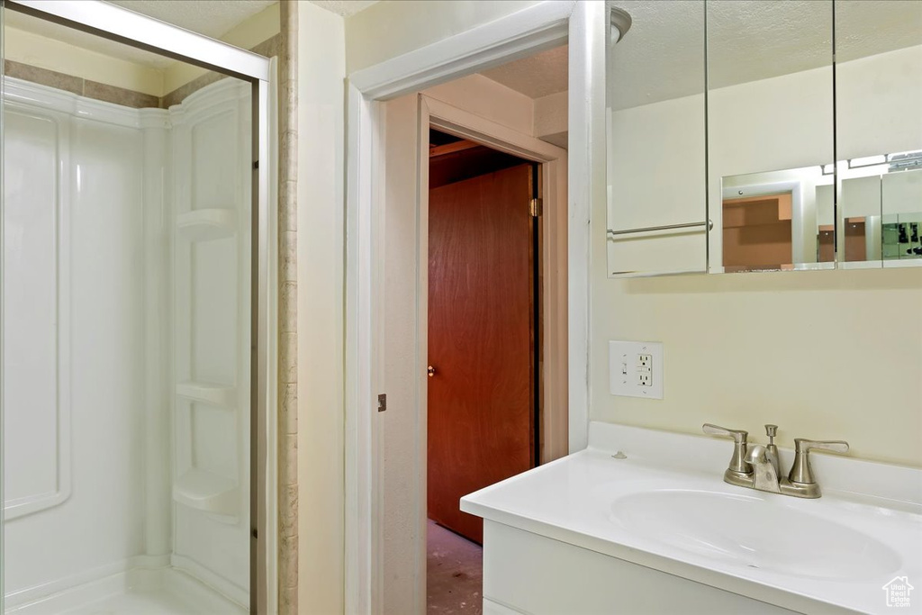 Bathroom featuring a shower stall and vanity