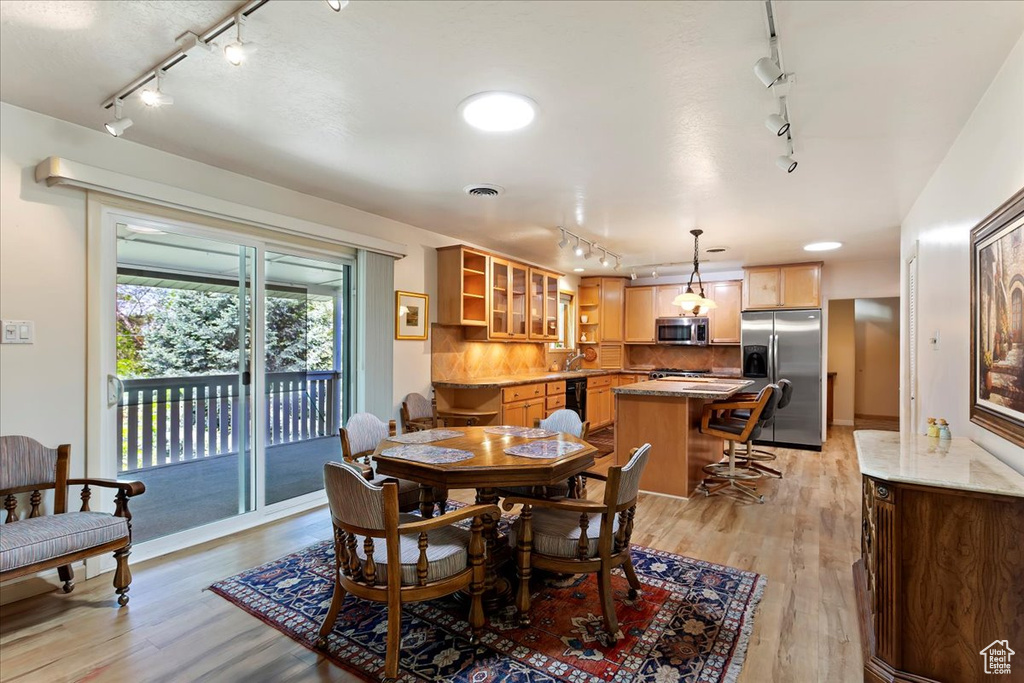 Dining space featuring rail lighting and light wood finished floors
