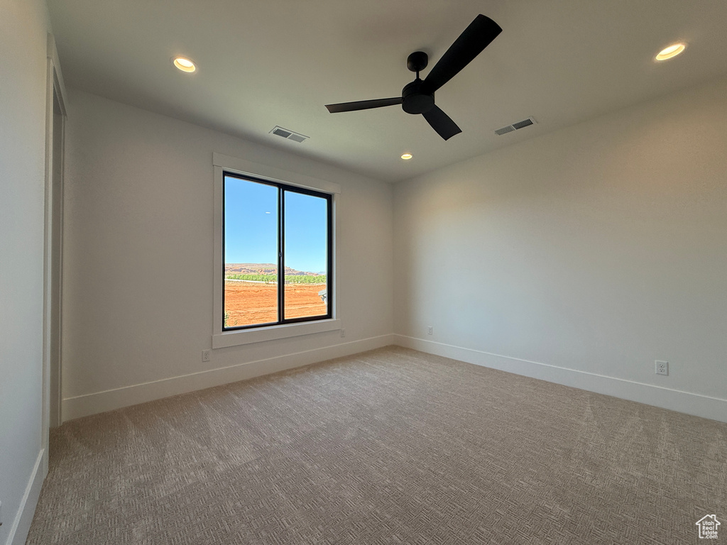 Empty room featuring light colored carpet, a ceiling fan, recessed lighting, and baseboards