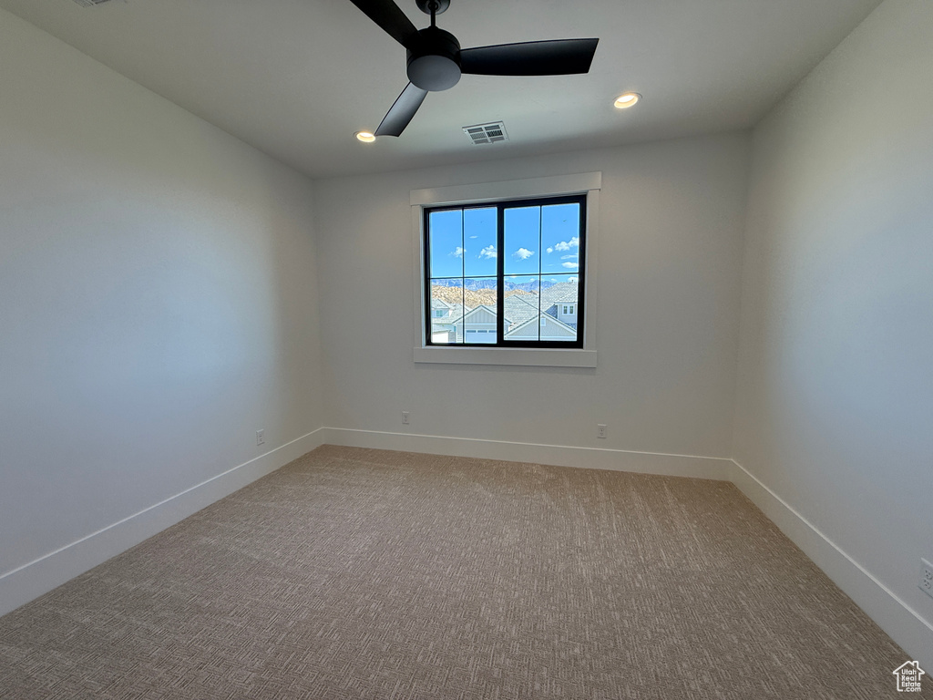 Empty room featuring ceiling fan, baseboards, light colored carpet, and recessed lighting