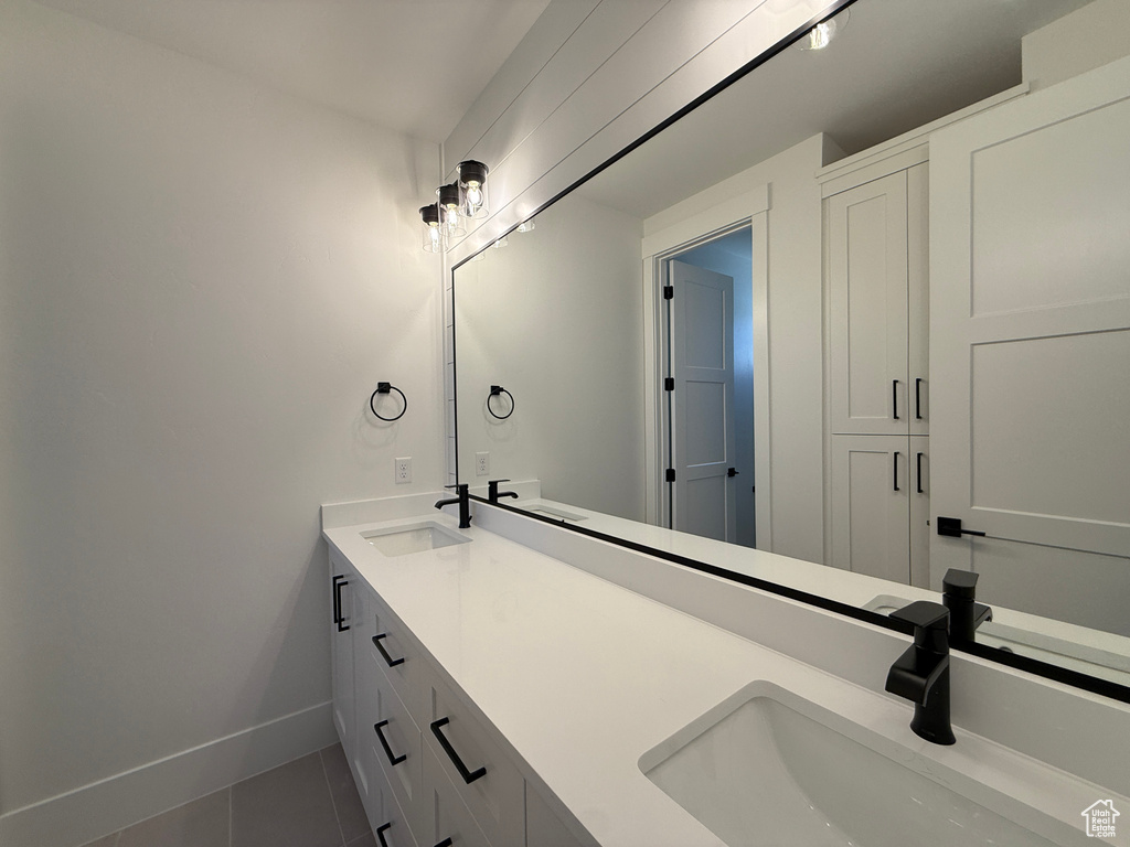 Bathroom with tile patterned flooring, baseboards, and double vanity