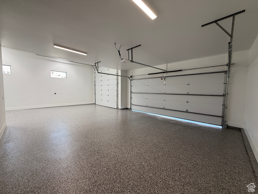 Garage with baseboards and a garage door opener