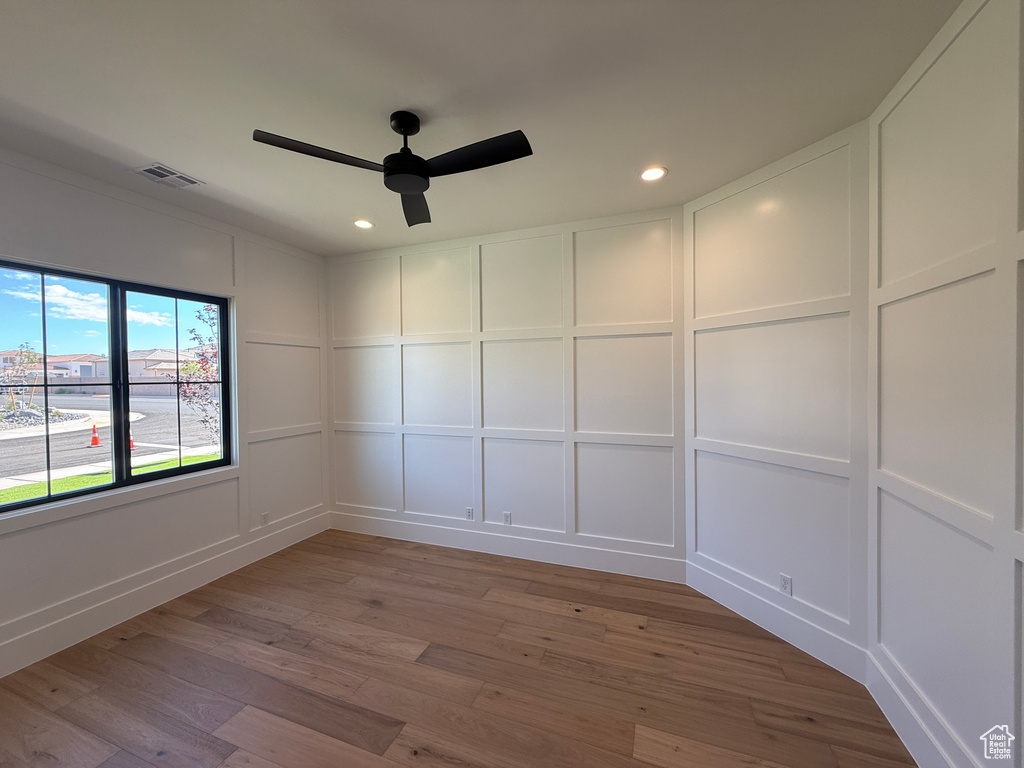Empty room with a decorative wall, ceiling fan, wood finished floors, and recessed lighting