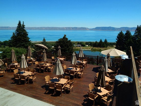 Wooden terrace featuring outdoor dining space and a water and mountain view