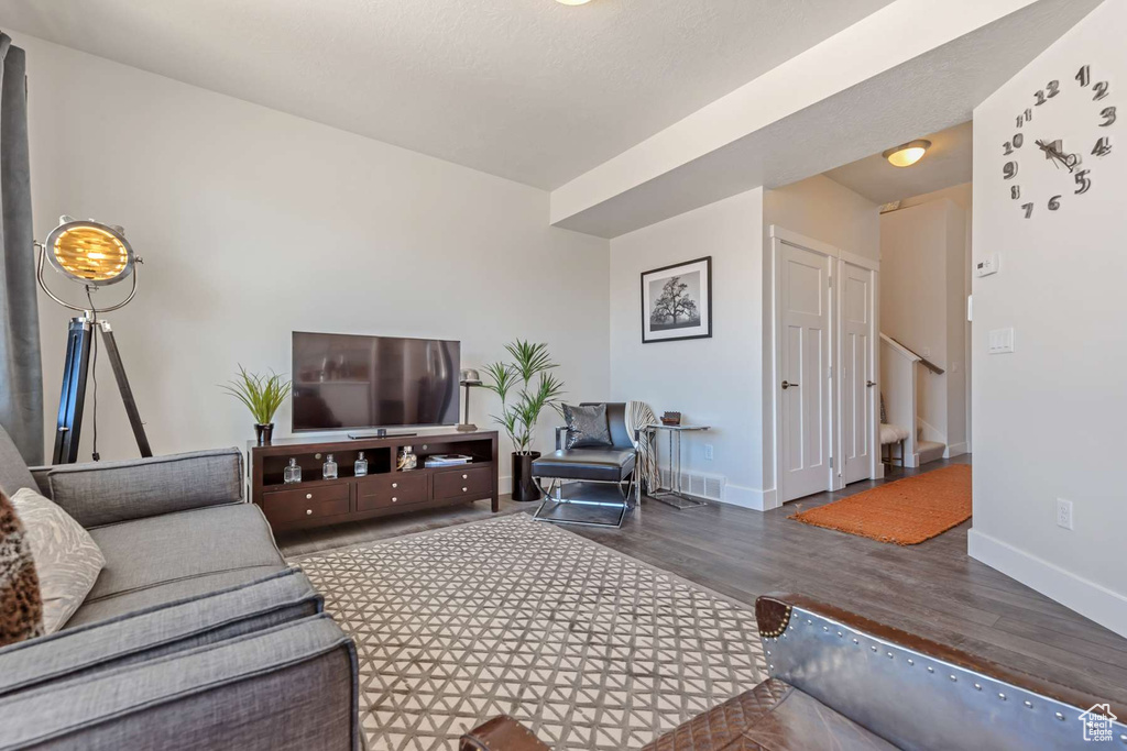 Living area with wood finished floors, baseboards, and stairs