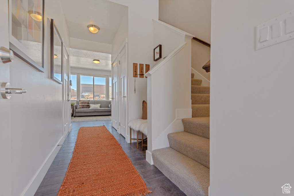 Hall featuring stairway, dark wood-type flooring, and baseboards