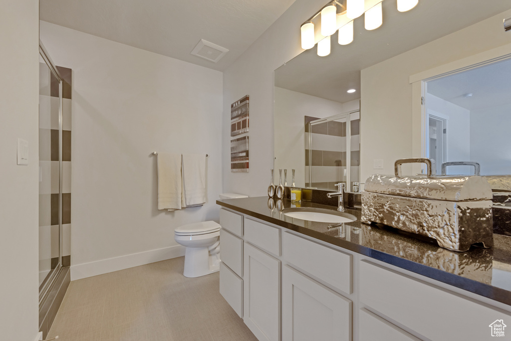 Full bathroom with a shower stall, toilet, vanity, and baseboards