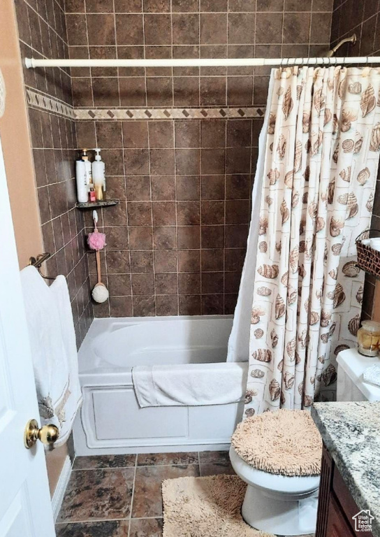 Full bathroom featuring shower / bathtub combination with curtain, vanity, and stone finish floors