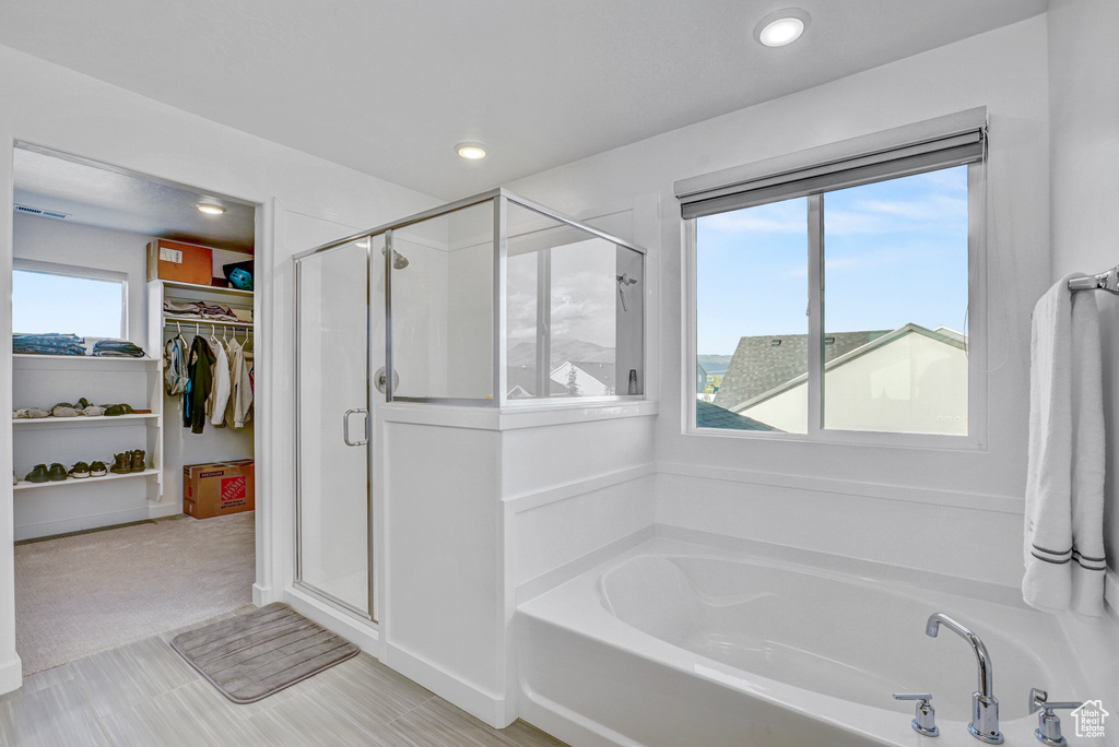 Full bath with a garden tub, a stall shower, a spacious closet, and recessed lighting