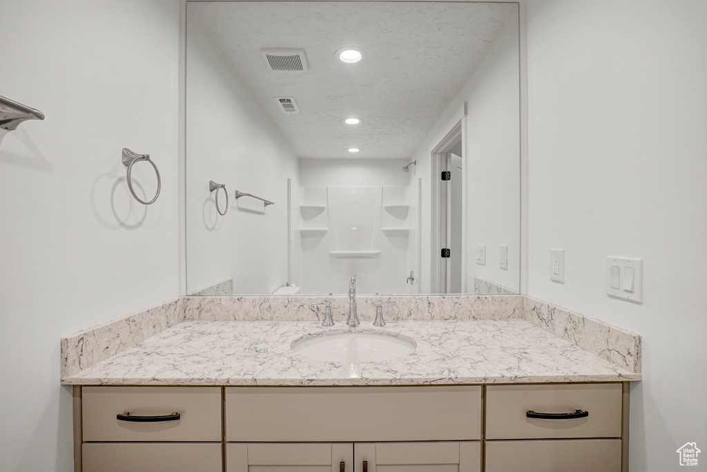 Bathroom featuring recessed lighting, a shower, and vanity