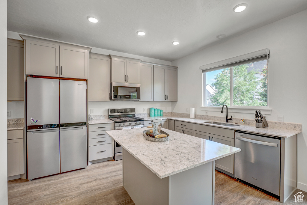 Kitchen with stainless steel appliances, a sink, gray cabinetry, a kitchen island, and recessed lighting