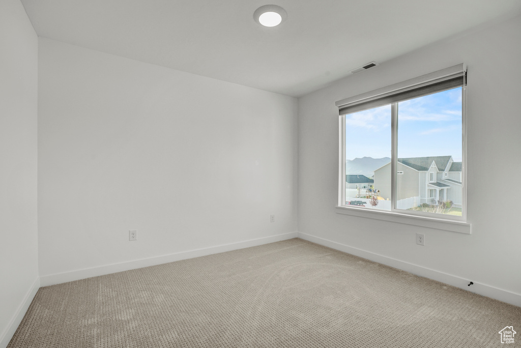 Unfurnished room featuring light colored carpet and baseboards