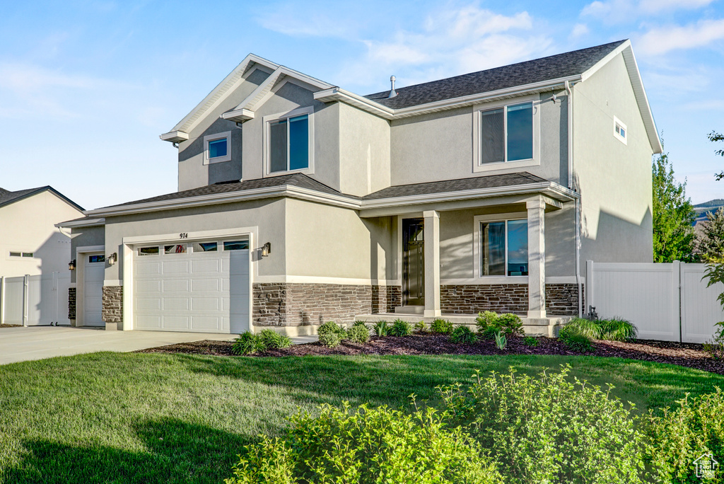 View of front of property with stone siding, concrete driveway, stucco siding, and a garage